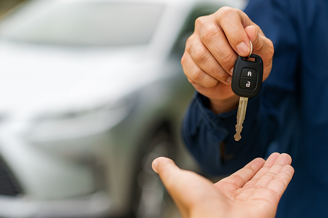 Technician programming a transponder car key with locksmith tools